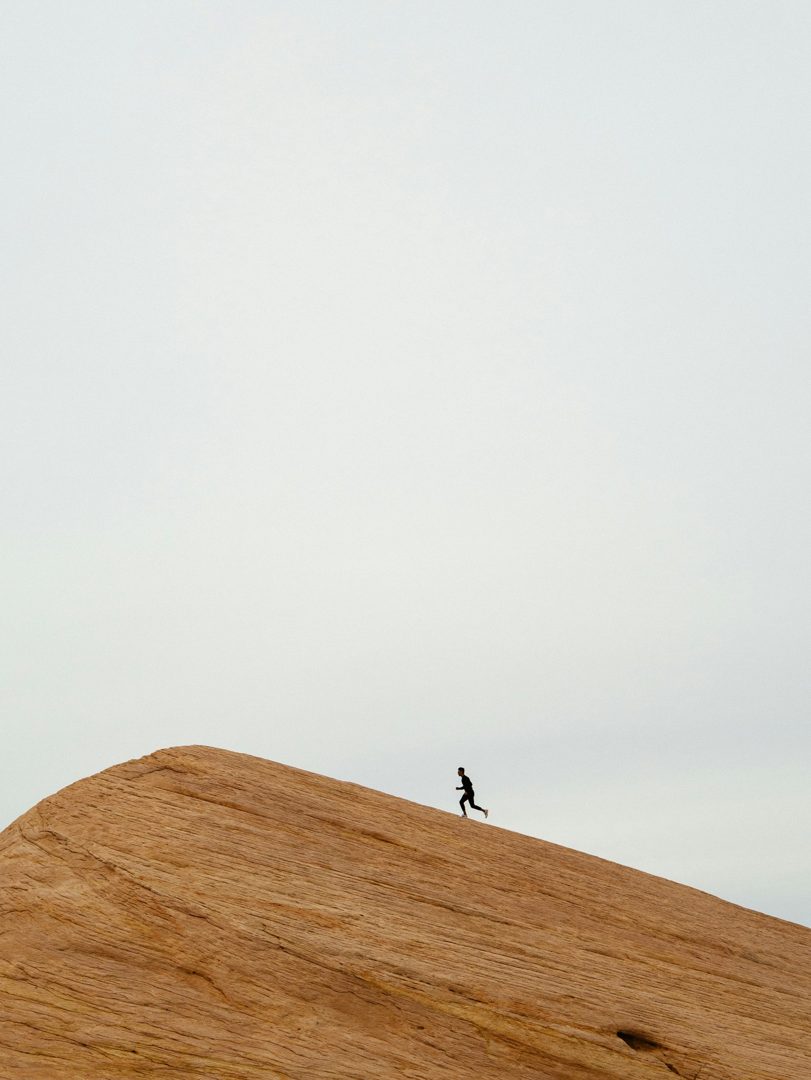 Runner cresting a sandstone ridge