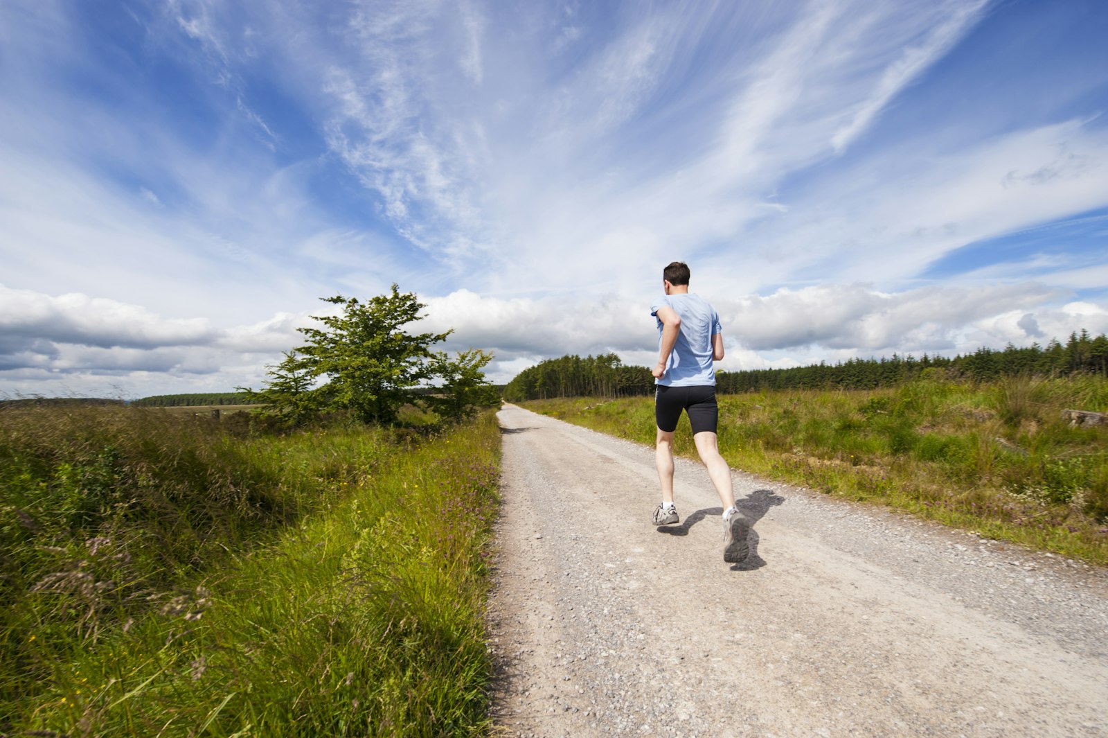 Runner on a gravel road through open country