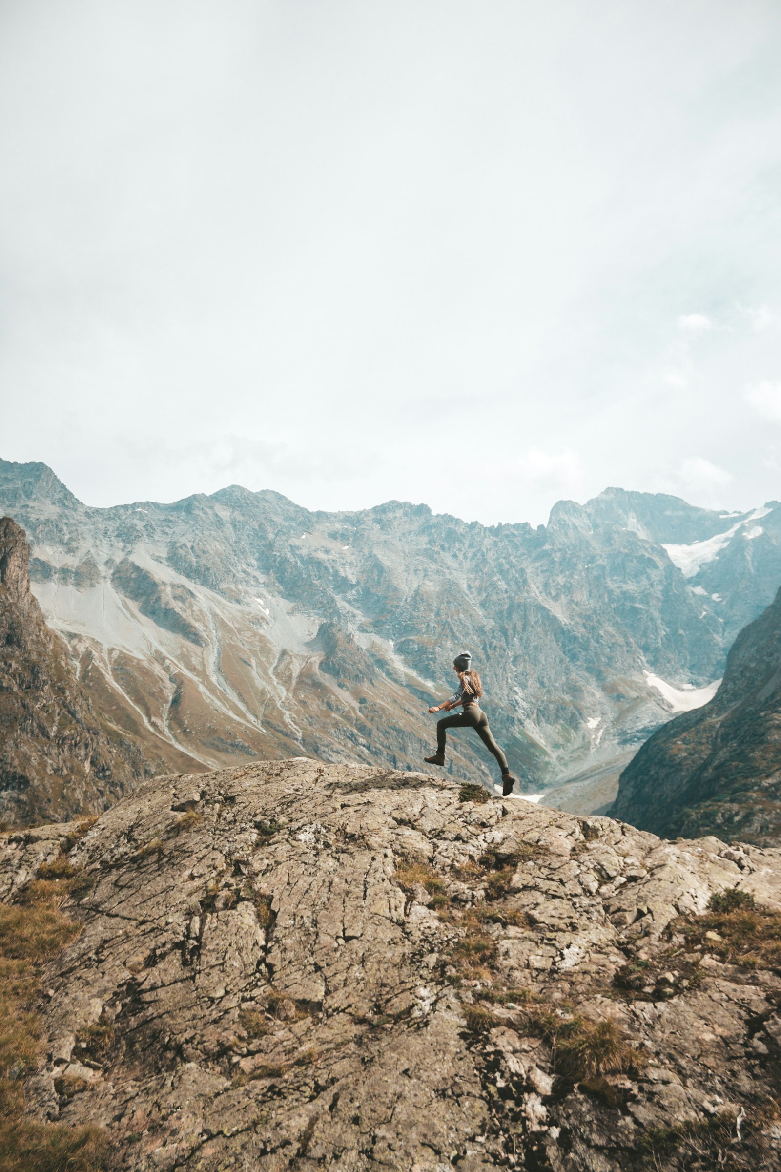 Runner leaping between rocks in the high mountains